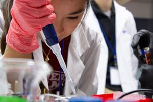 a young woman of asian descent works with a pipette in the lab