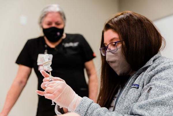 Medical student trains to give vaccines at Simulation Center