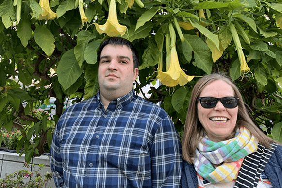 Bob Avera and Mary Wermuth standing in front of an Angel trumpet
