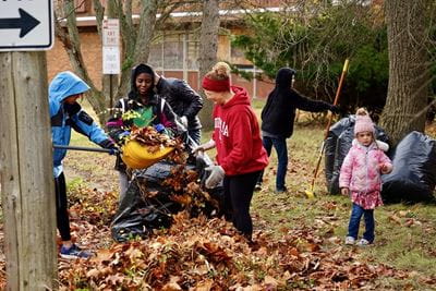Michelle LaTurner and her family rake leaves with other Urban Medicine students