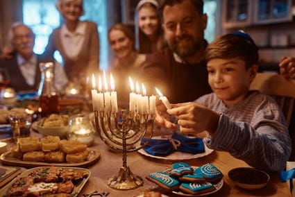 Family lighting menorah candles