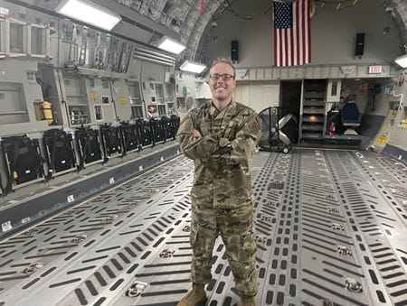 Dr. Taylor in military fatigues inside an aircraft