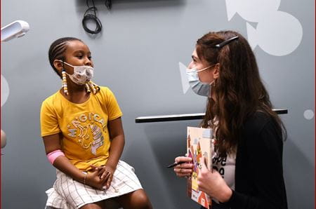 Dr. Julia LaMotte giving a book to a sickle cell patient
