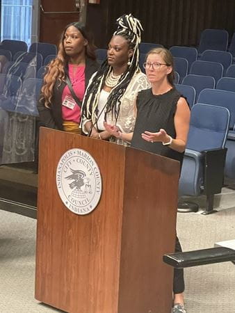 Lauren Magee speaks at City-County Council with gun violence prevention advocates DeAndra Dycus and Antonia Bailey