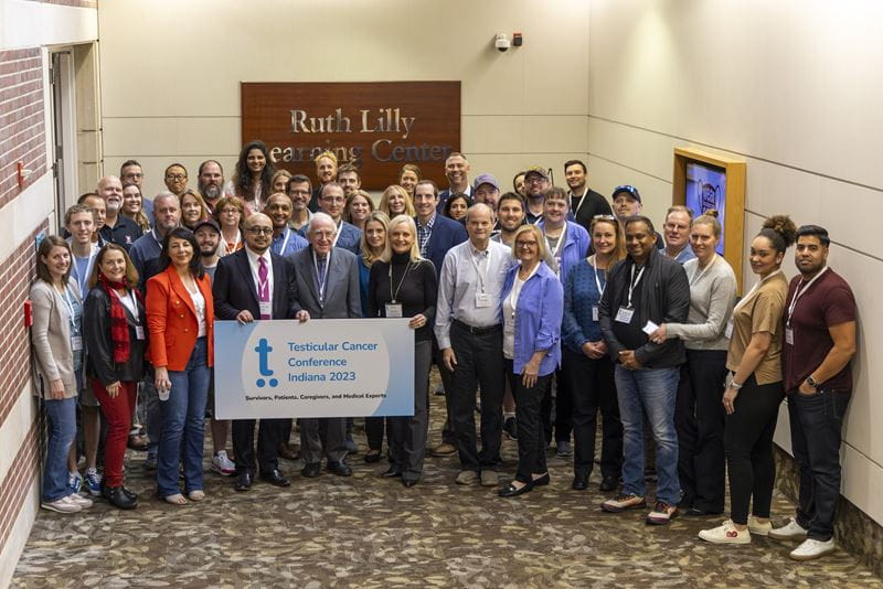 Group photo of Testicular Cancer Conference attendees in front of the Ruth Lilly Learning Center sign