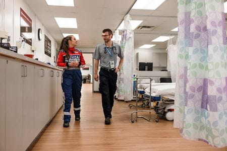Julia Vaizer walks through the Infield Care Center with emergency medicine resident Grant Geiger.