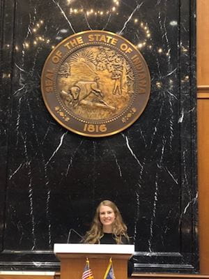 Adaline Heitz stands under the state seal at the Indiana Statehouse