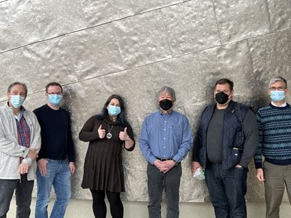 Hannah Kline posing along wall with her PhD Committee: Dave McKinsey, Brady Atwood, Bryan Yamamoto, Bill Truitt and Eric Engleman (all wearing protective masks).