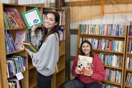 two students shelve books at the Hoosier Hills Food Bank annual book drive
