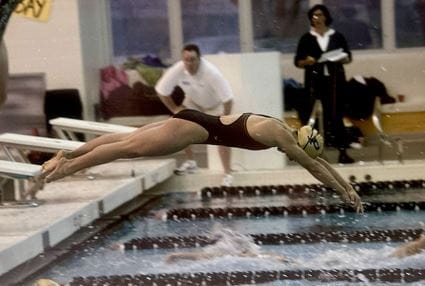 Kimbre Zahn, in swimming attire, dives off a platform in a meet for Purdue