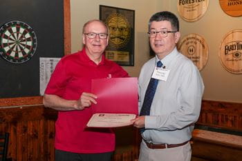 Dean Jay Hess stands with Dr. Naoyuki Saito, displaying his award certificate