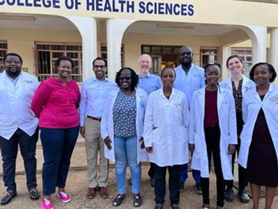 Photo of 10 people in front of college of health sciences in Kenya