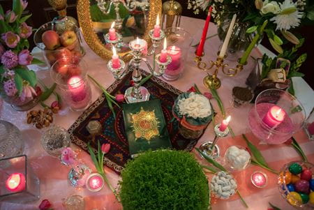 flowers food and candles on a table prepared for naw ruz or persian new year