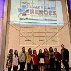 Group photo of 10 diabetes researchers at the IBJ Health Care Heroes awards posing near the event's sign