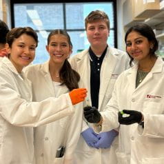 4 MMIA students posing in a lab during the MMIA 2024 program