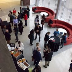 Photo from above of individuals mingling at the Research Synergy Summit