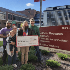 Turi family visiting the Wells Center with check