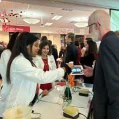 Wells Center scientists demonstrating lab techniques to Riley gala guest
