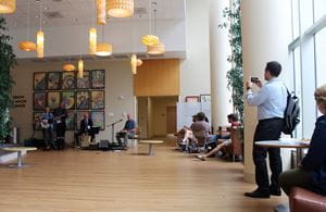 A man uses his cellphone to take a picture of the band "the Crooked Finger Rhythm Review," as its members play in the lobby of the Simon Cancer Center