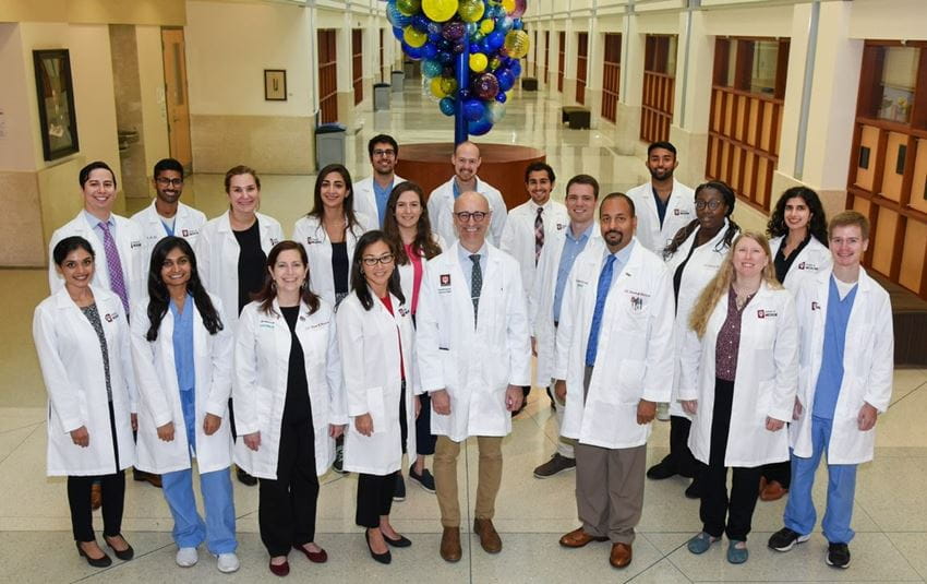 Group photo of Internal Medicine residents and program leadership. Wearing formal white coats.