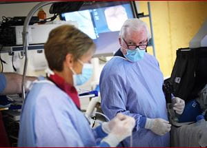 Photo of Dr. Lehman in the endoscopy suite during a procedure talking to a colleague.