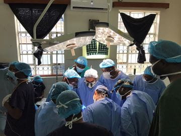 A group of physicians huddle together in an operating room at Moi Teaching and Referral Hospital in Eldoret, Kenya.
