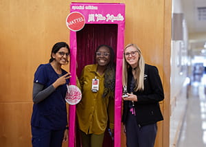 Person in oversized barbie box with two friends outside