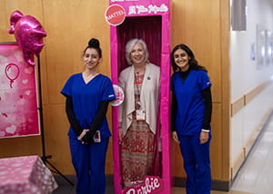 Teacher in oversized barbie box with students next to her