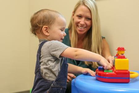 a toddler plays with toys in the early autism evaluation hub
