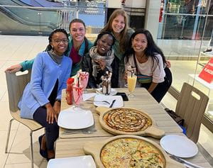 5 people eating pizza at the mall