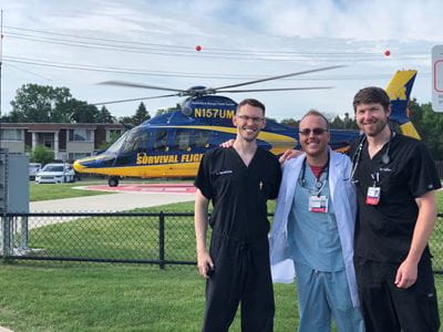Dr Taylor and colleagues in front of a helicopter